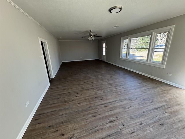 empty room featuring ceiling fan, crown molding, dark wood-type flooring, and a textured ceiling