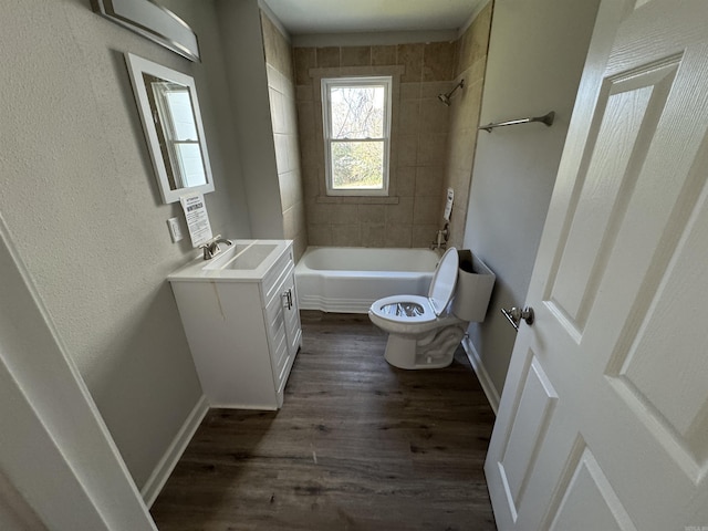 full bathroom with hardwood / wood-style flooring, vanity, toilet, and tiled shower / bath