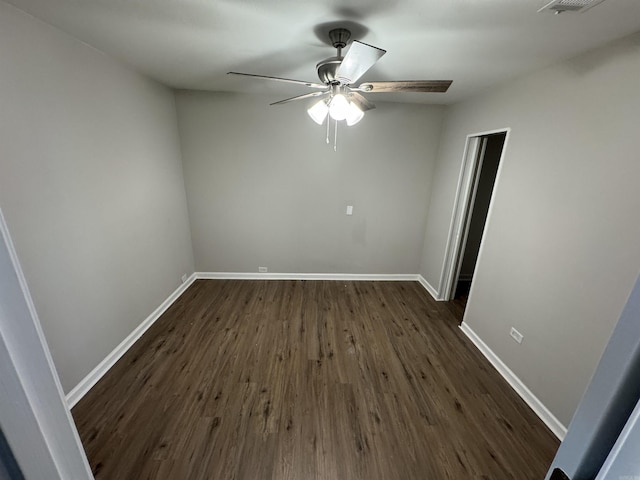 spare room featuring ceiling fan and dark wood-type flooring