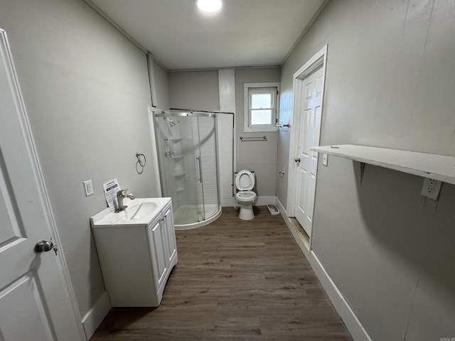 bathroom with hardwood / wood-style flooring, toilet, vanity, and walk in shower