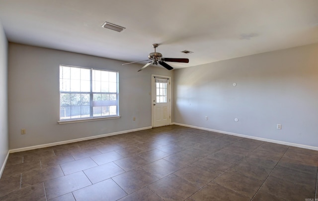 unfurnished room featuring ceiling fan and dark tile patterned floors