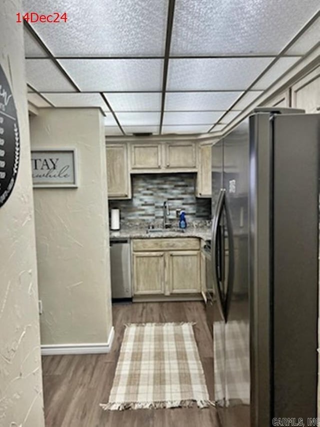 kitchen with light brown cabinets, a drop ceiling, tasteful backsplash, dark hardwood / wood-style floors, and appliances with stainless steel finishes