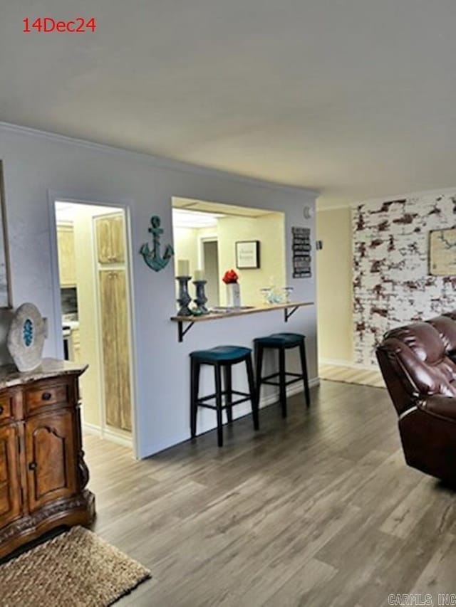 living room with crown molding and light hardwood / wood-style flooring