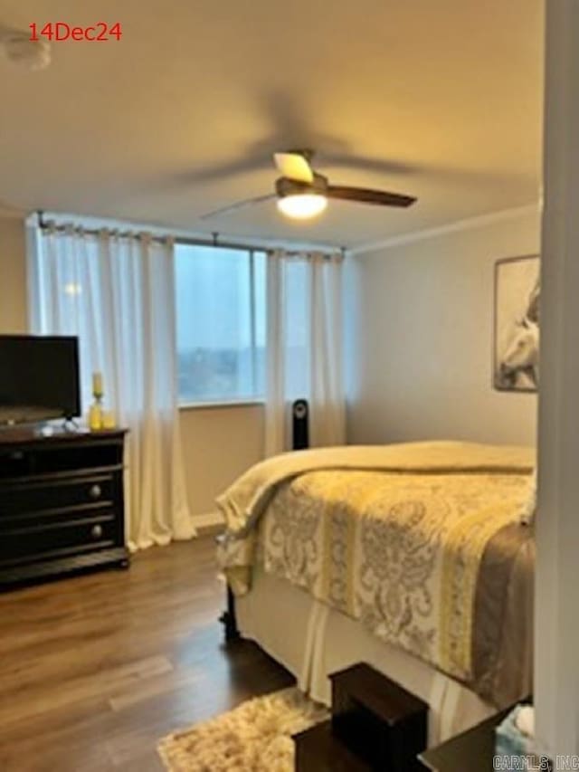 bedroom featuring ceiling fan, crown molding, and dark wood-type flooring