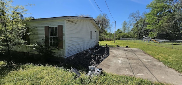 view of home's exterior featuring a patio, a trampoline, and a lawn