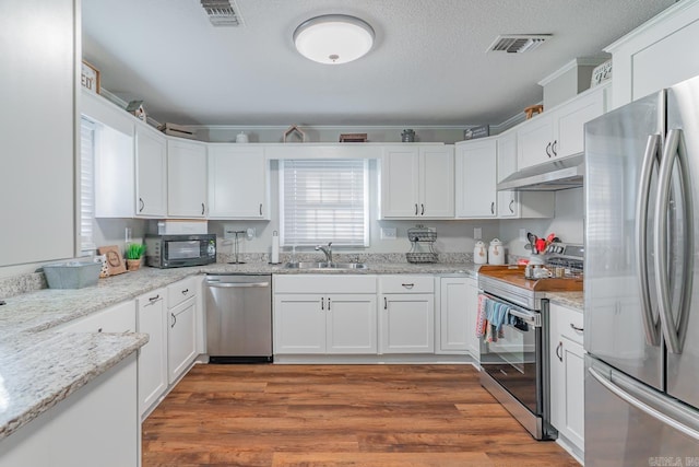 kitchen featuring light stone countertops, white cabinetry, sink, and stainless steel appliances