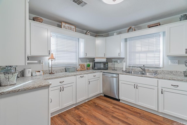 kitchen with stainless steel dishwasher, white cabinets, sink, and hardwood / wood-style flooring