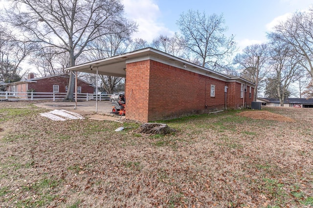 view of property exterior featuring central AC and a carport