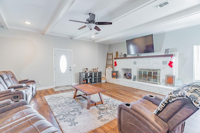 living room featuring beamed ceiling, a wealth of natural light, light hardwood / wood-style floors, and ceiling fan