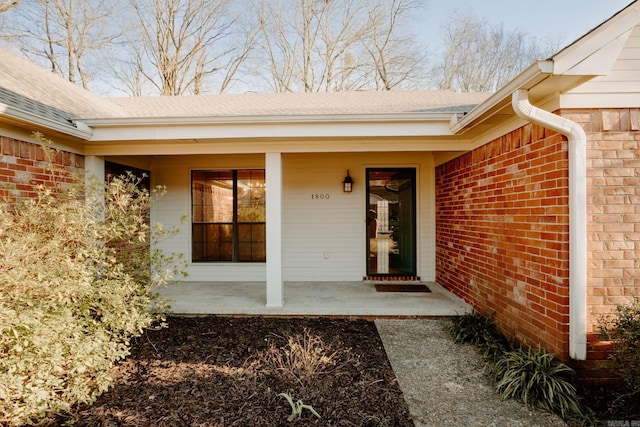 view of exterior entry with a porch