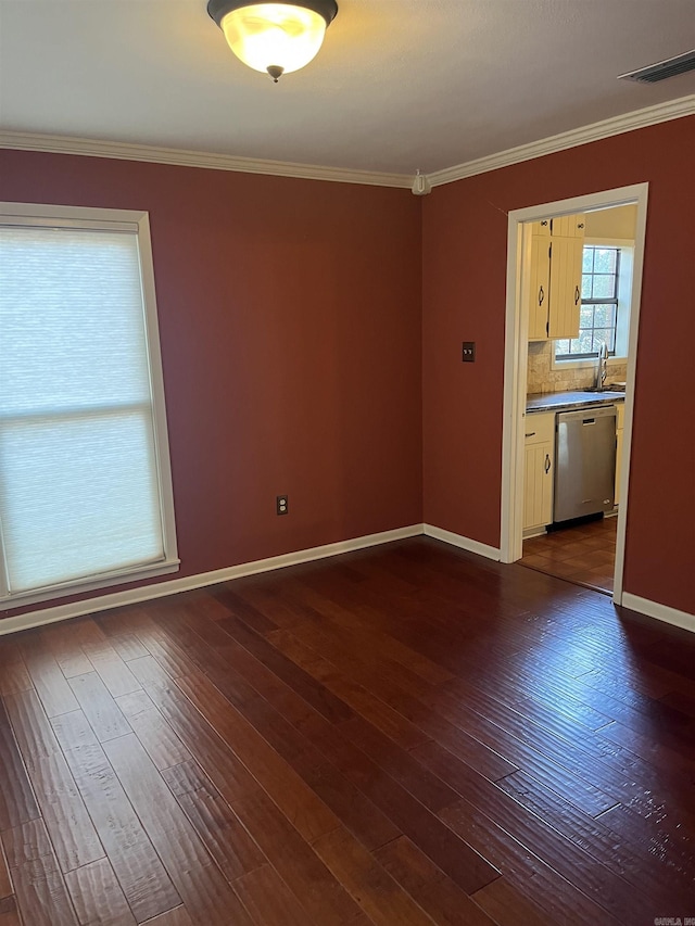 spare room featuring dark hardwood / wood-style floors and crown molding