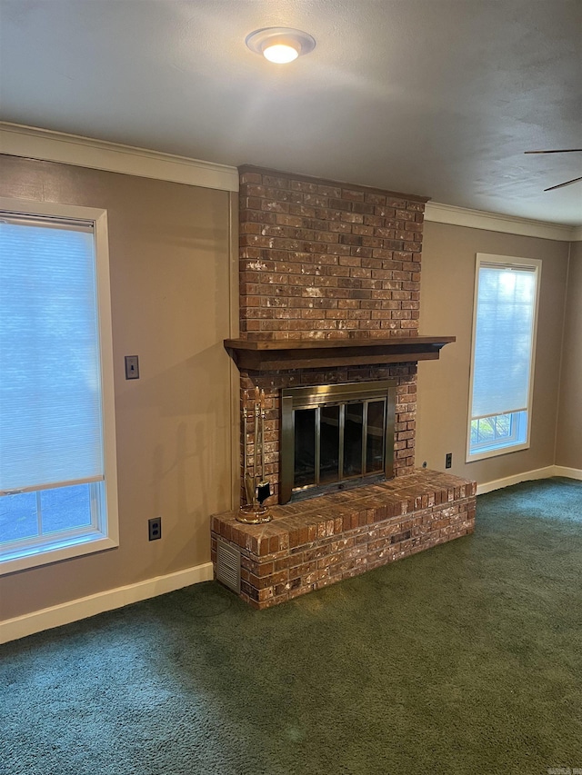 unfurnished living room featuring crown molding, plenty of natural light, carpet floors, and a brick fireplace