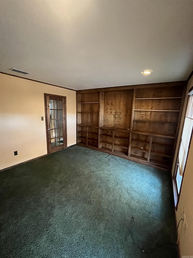 carpeted empty room featuring built in features