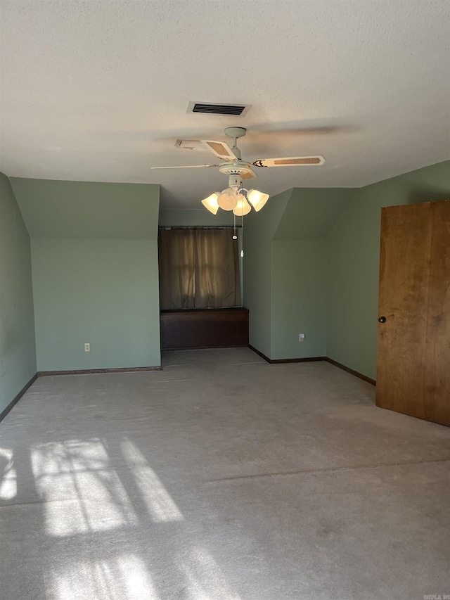 spare room featuring a textured ceiling, ceiling fan, and lofted ceiling