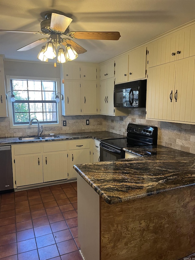 kitchen with sink, dark tile patterned floors, dark stone countertops, white cabinets, and black appliances