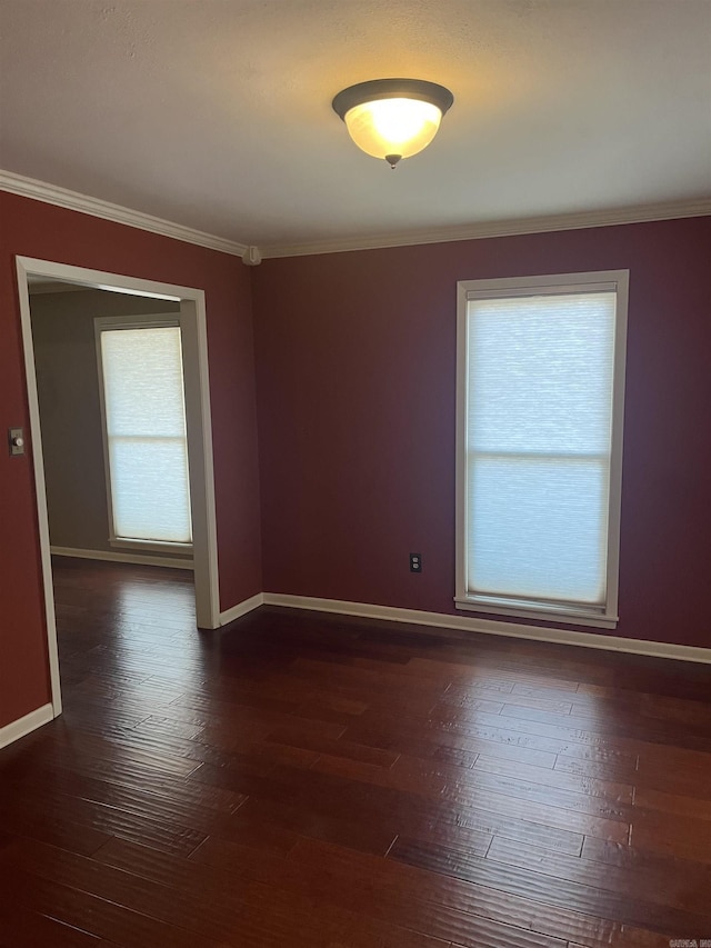 empty room featuring dark hardwood / wood-style flooring and ornamental molding