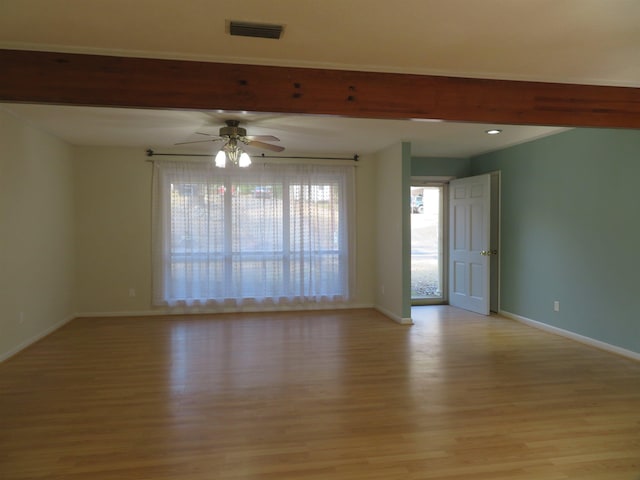 empty room featuring ceiling fan, light hardwood / wood-style floors, and beamed ceiling