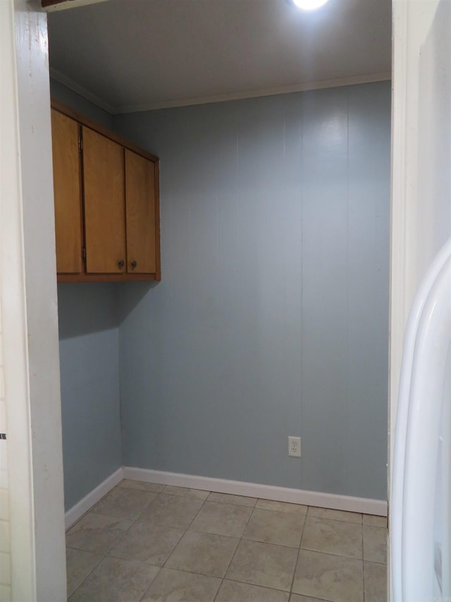 laundry area featuring crown molding and light tile patterned floors