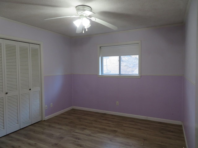 unfurnished bedroom with ceiling fan, hardwood / wood-style floors, a closet, and a textured ceiling