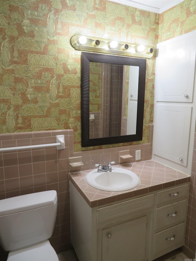 bathroom with vanity, tile walls, and toilet