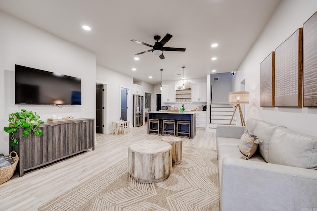 living room featuring light wood-type flooring and ceiling fan