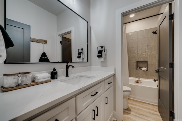 full bathroom featuring hardwood / wood-style floors, vanity, toilet, and shower / tub combo