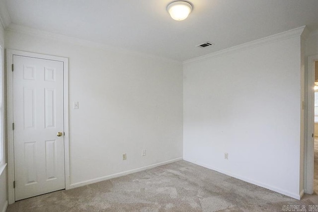 spare room featuring light colored carpet and crown molding