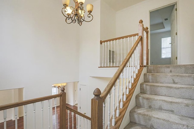 staircase with a chandelier and hardwood / wood-style flooring