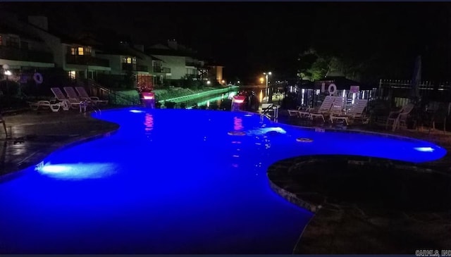 pool at twilight with a patio area