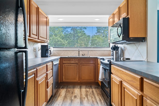 kitchen with black appliances, sink, ornamental molding, tasteful backsplash, and wood-type flooring