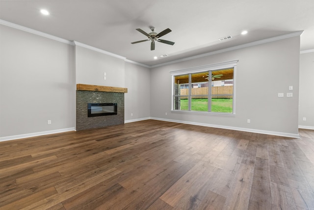 unfurnished living room with a stone fireplace, ceiling fan, dark hardwood / wood-style floors, and ornamental molding