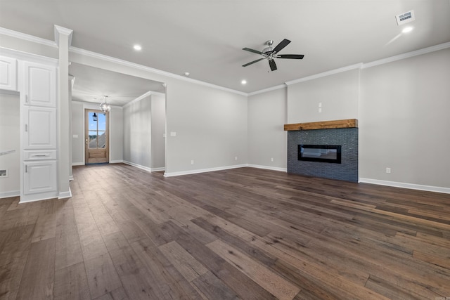 unfurnished living room featuring ceiling fan, a stone fireplace, ornamental molding, and dark wood-type flooring