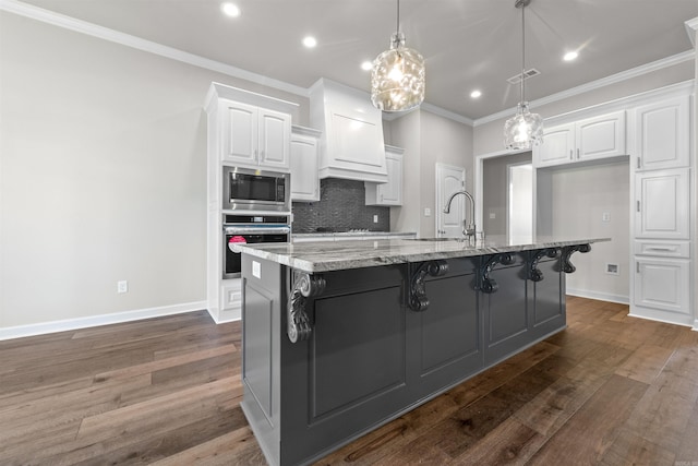 kitchen with white cabinetry, hanging light fixtures, light stone counters, a spacious island, and appliances with stainless steel finishes