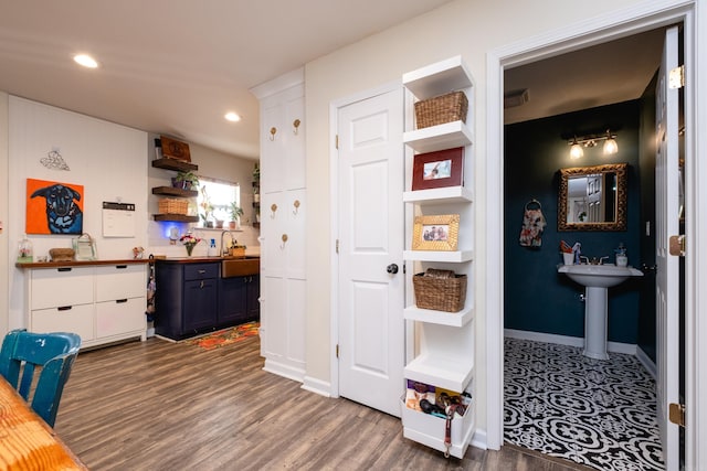 interior space with wood counters, white cabinetry, sink, and dark wood-type flooring