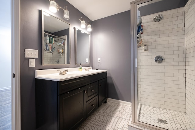 bathroom with tiled shower, vanity, and tile patterned floors