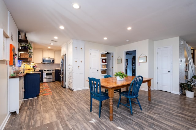 dining space featuring sink and dark wood-type flooring