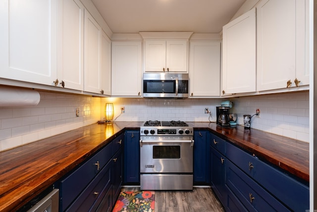 kitchen featuring butcher block countertops, blue cabinetry, white cabinets, and stainless steel appliances