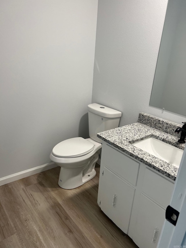 bathroom featuring hardwood / wood-style floors, vanity, and toilet