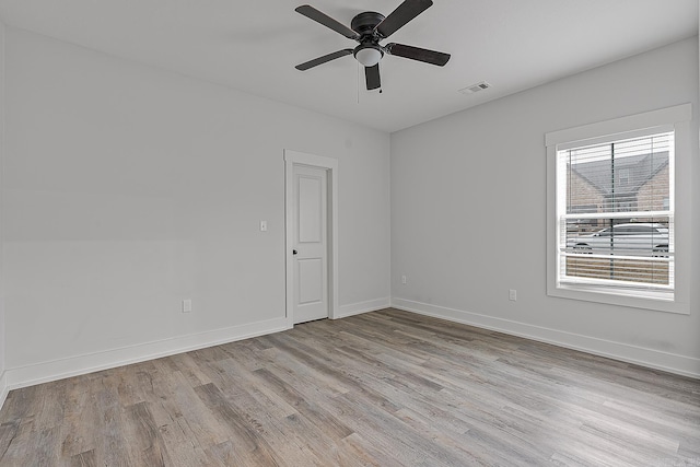 empty room with ceiling fan and light hardwood / wood-style flooring