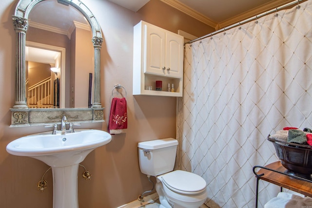 bathroom featuring toilet, curtained shower, crown molding, and sink