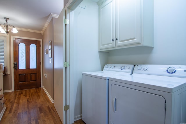 laundry room with cabinets, a chandelier, ornamental molding, dark hardwood / wood-style flooring, and washing machine and clothes dryer