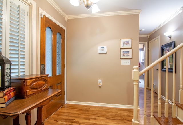 foyer entrance featuring a chandelier, light wood-type flooring, and ornamental molding