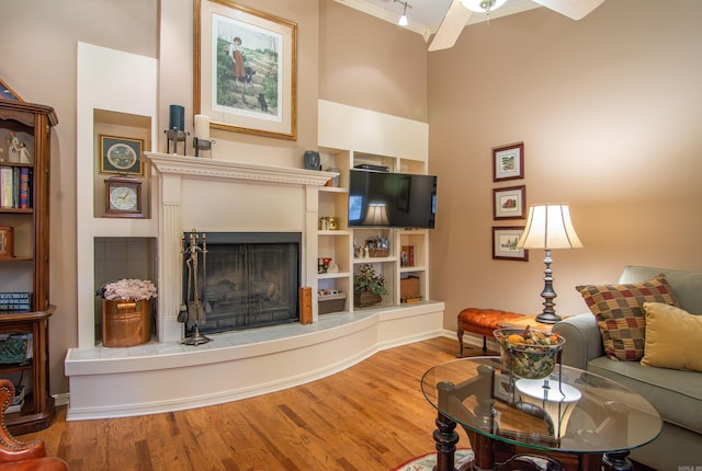 living room with a tile fireplace, ceiling fan, and hardwood / wood-style flooring