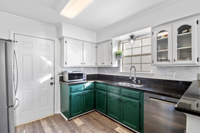 kitchen featuring sink, stainless steel appliances, green cabinets, white cabinets, and hardwood / wood-style flooring