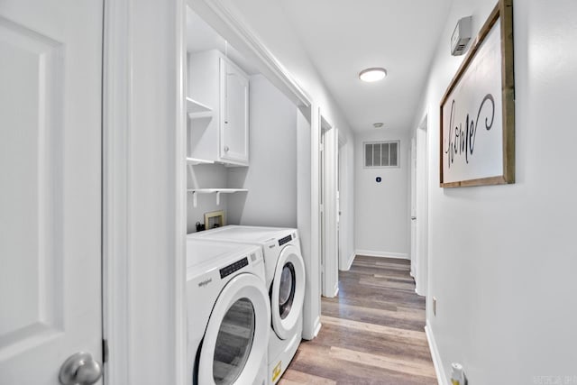 clothes washing area featuring light wood-type flooring and washing machine and clothes dryer