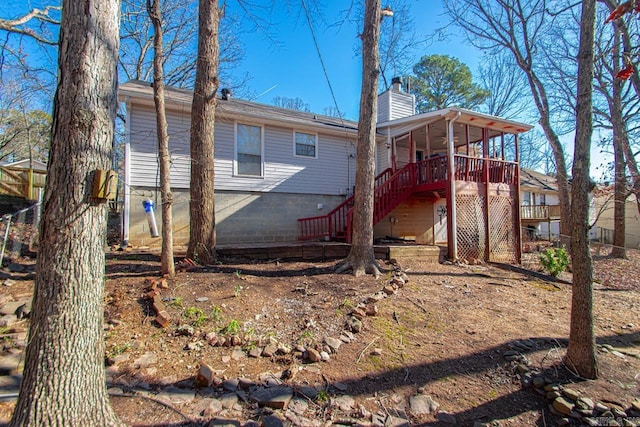 rear view of house featuring a wooden deck