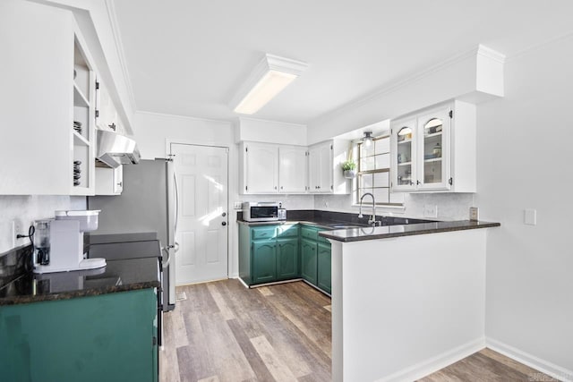 kitchen featuring kitchen peninsula, light hardwood / wood-style floors, white cabinetry, and sink