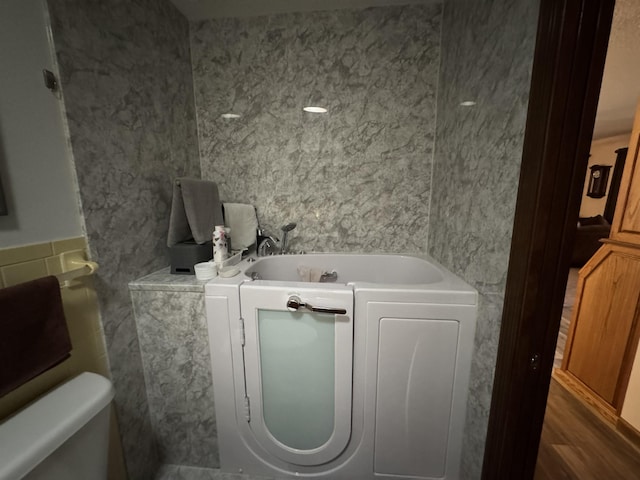 bathroom featuring a bathtub and tile walls