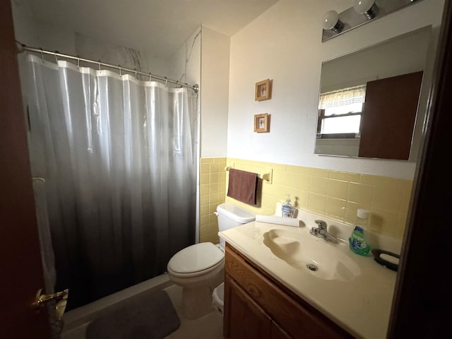 bathroom featuring vanity, curtained shower, toilet, and tile walls