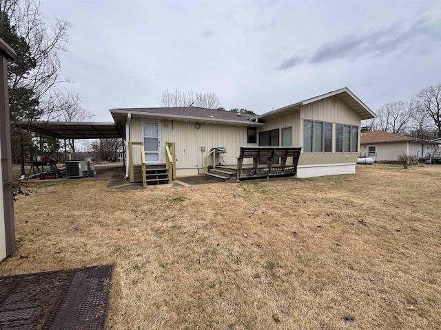 rear view of house featuring a lawn, a wooden deck, central AC unit, and a carport